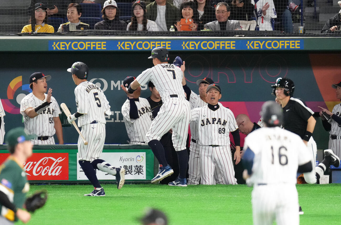 日本対オーストラリア　8回、適時二塁打の佐藤（中央）はベンチに戻り井端監督（同右）らにタッチで迎えられる（撮影・足立雅史）
