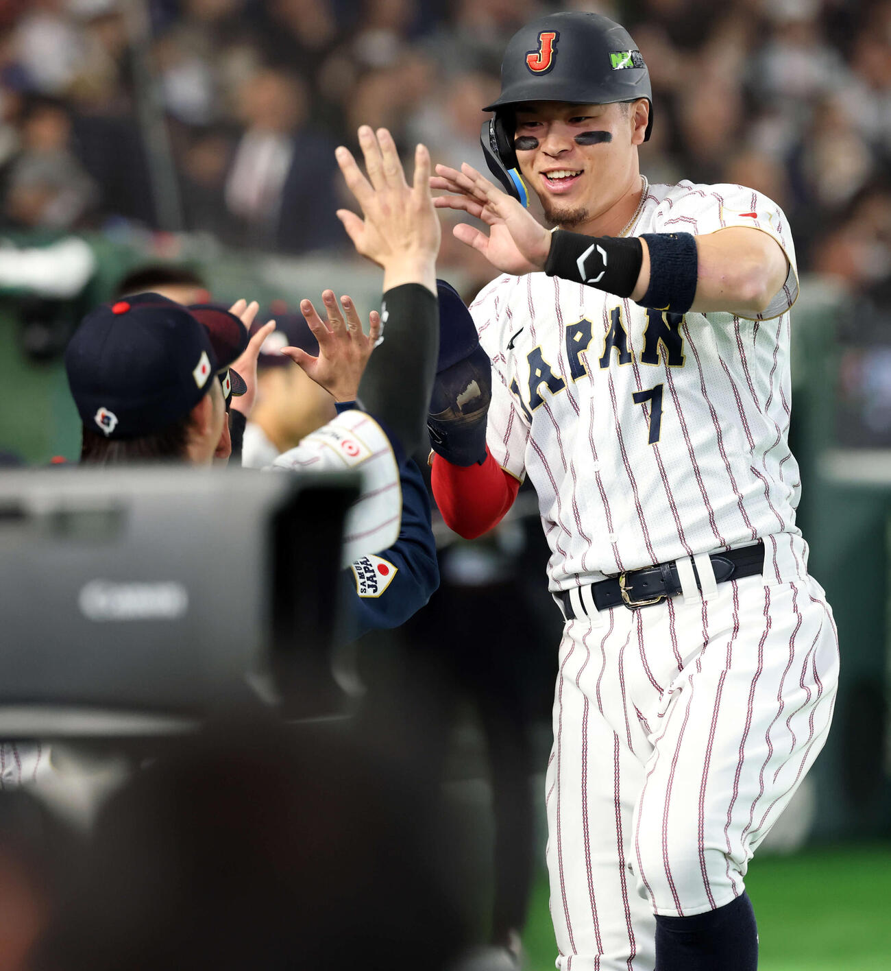 日本対オーストラリア　8回裏日本の攻撃で左適時二塁打を放った佐藤はベンチでナインとハイタッチ（撮影・浅見桂子）
