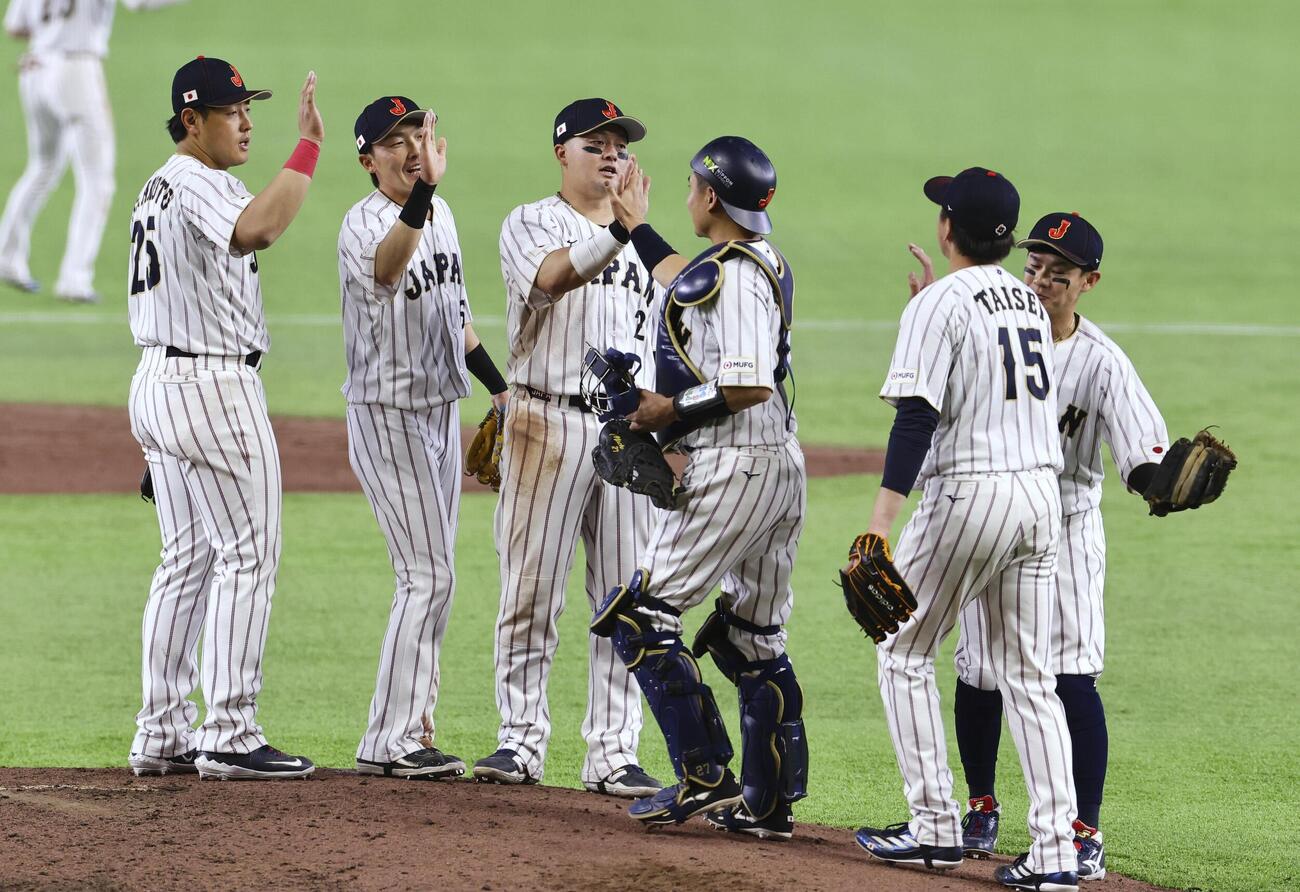 オーストラリアに勝利して1次リーグC組1位通過を決め、タッチを交わす日本の選手たち（共同）