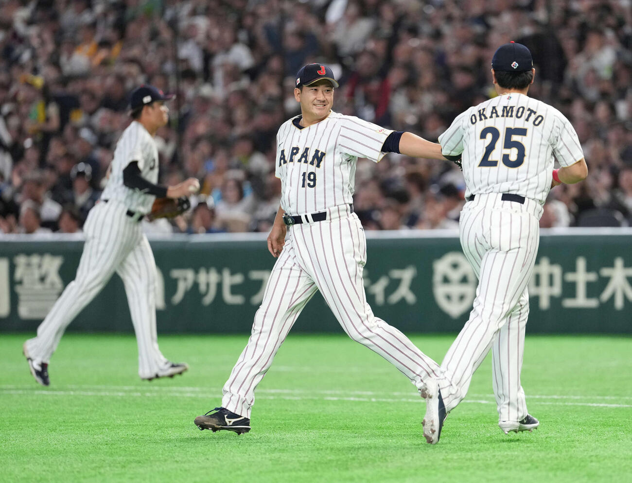 日本対オーストラリア　3回を無失点で終え笑顔で岡本（右）とタッチする菅野（撮影・井上学