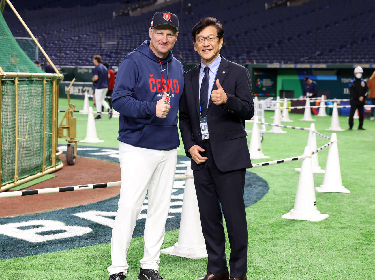 3月7日、チェコ対台湾　試合前、チェコのハジム監督（左）とサムズアップで記念撮影する同国の野球名誉アンバサダーを務める栗山英樹氏