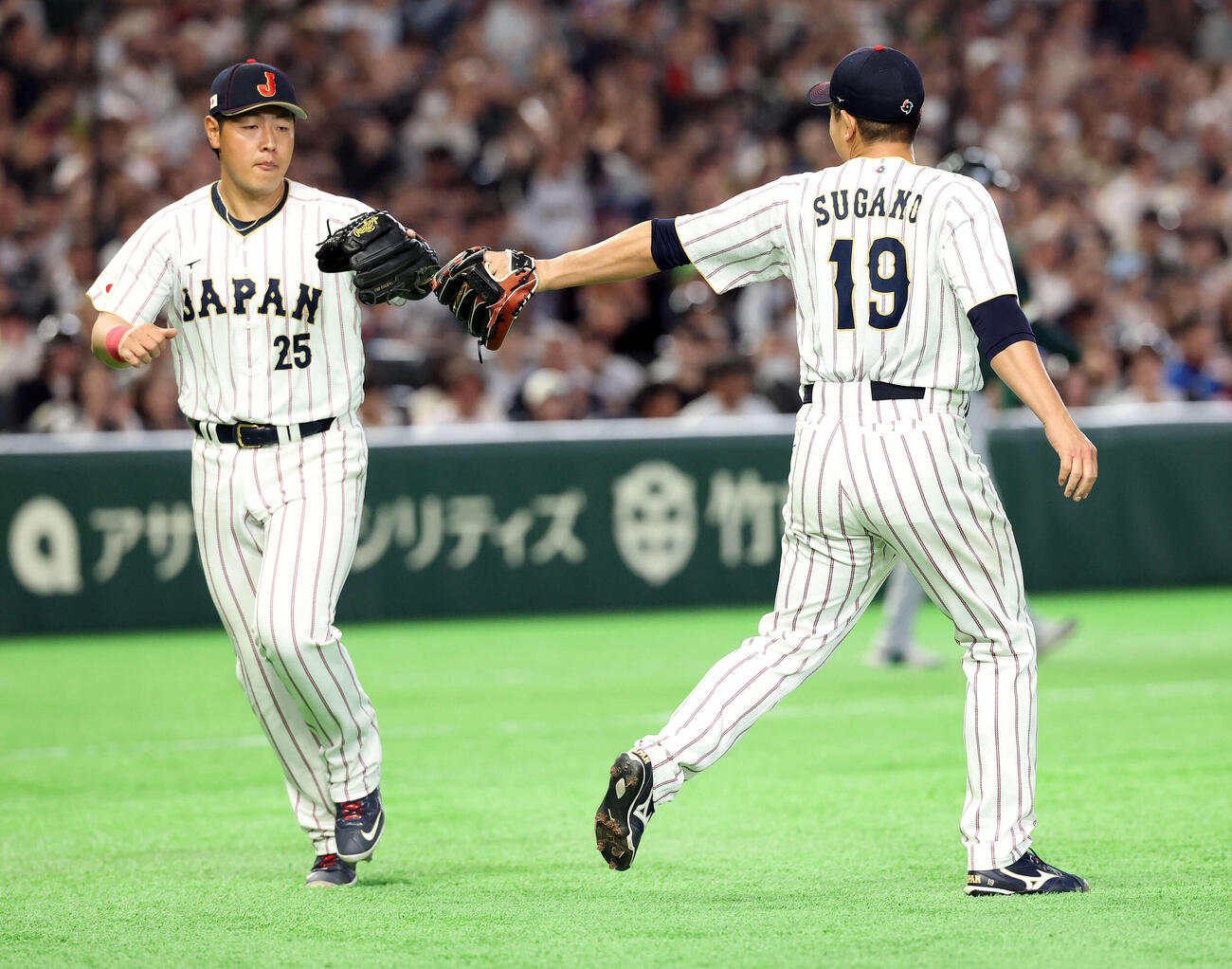2026年3月、日本対オーストラリア　3回表オーストラリア1死一塁、ミードの打球を岡本（左）が好守で併殺に仕留めグラブタッチする菅野
