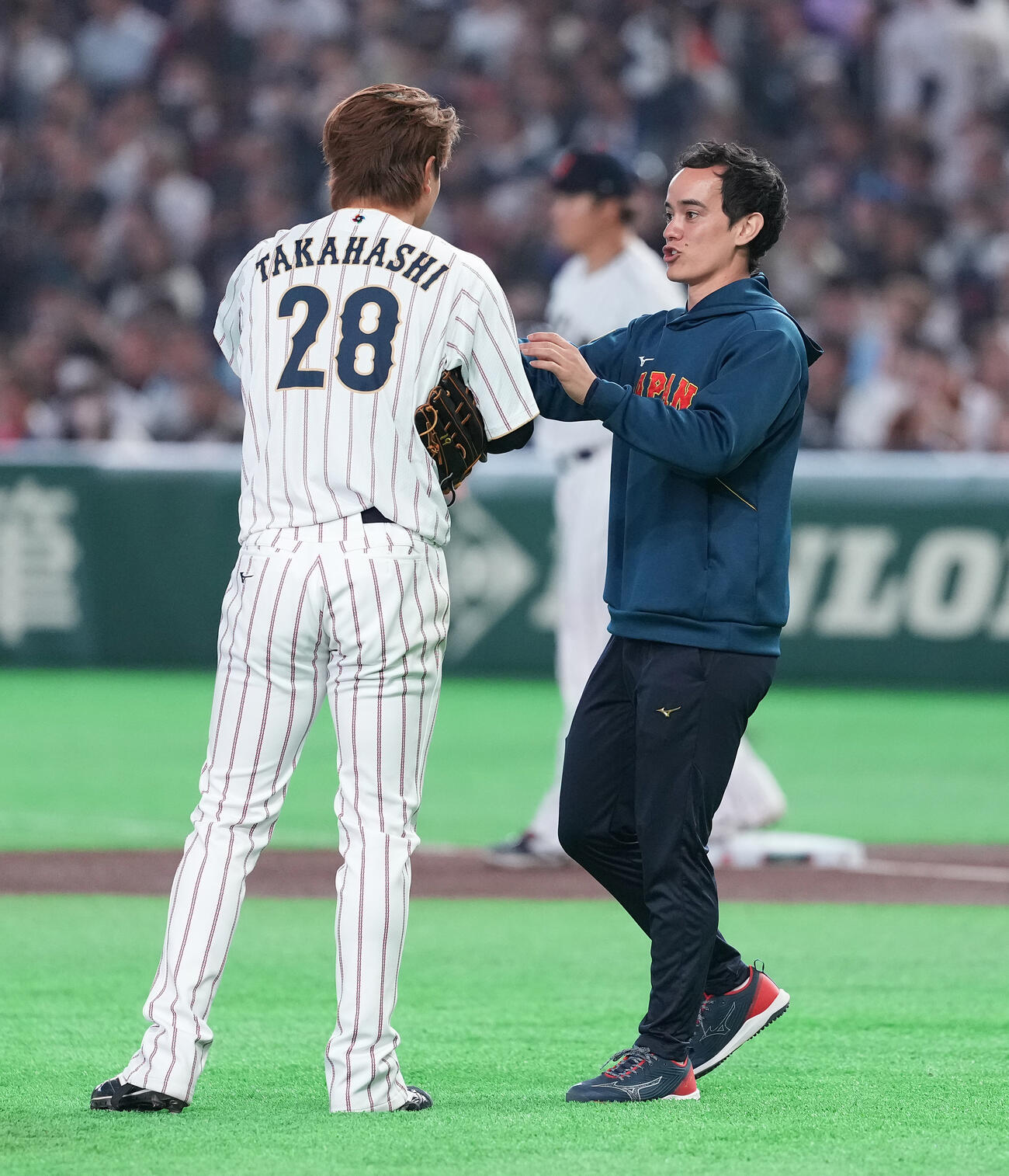 日本対チェコ　高橋宏（左）の帽子にピッチコムをつけるアイアトン氏（撮影・鈴木みどり）