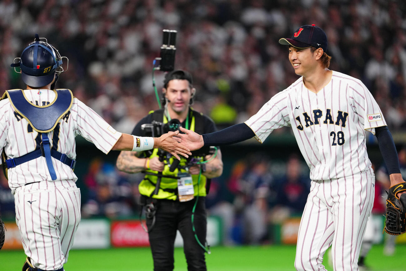 日本対チェコ　2回表終了後、捕手中村悠（左）とタッチを交わす先発の高橋宏（撮影・江口和貴）