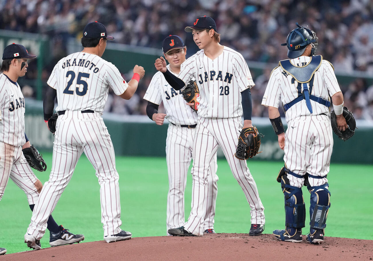 日本対チェコ　5回表、降板する先発高橋宏（中央）はナインとタッチを交わす（撮影・鈴木みどり）