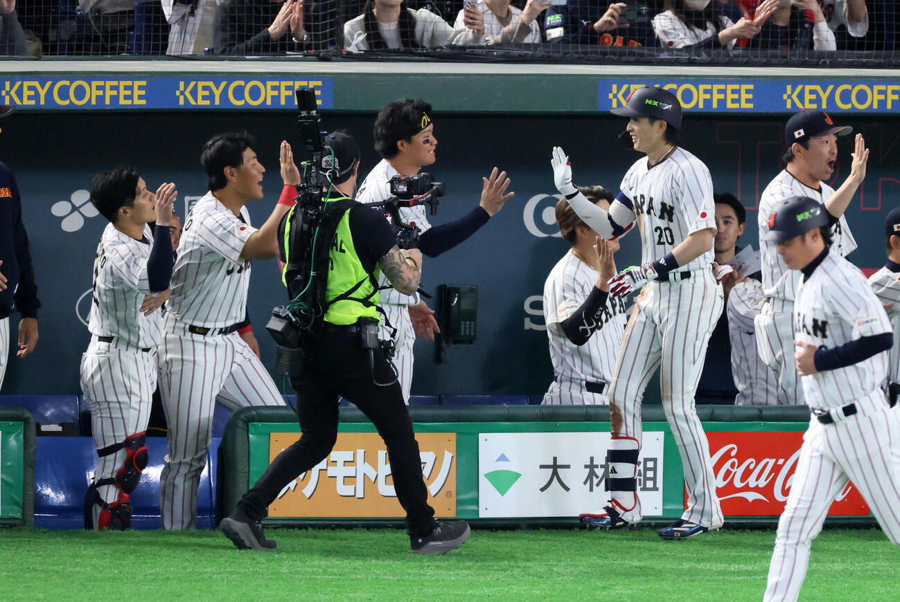 日本対チェコ　8回裏日本2死一、二塁、周東は右越え3点本塁打を放ちベンチのナインとタッチする（撮影・加藤哉）