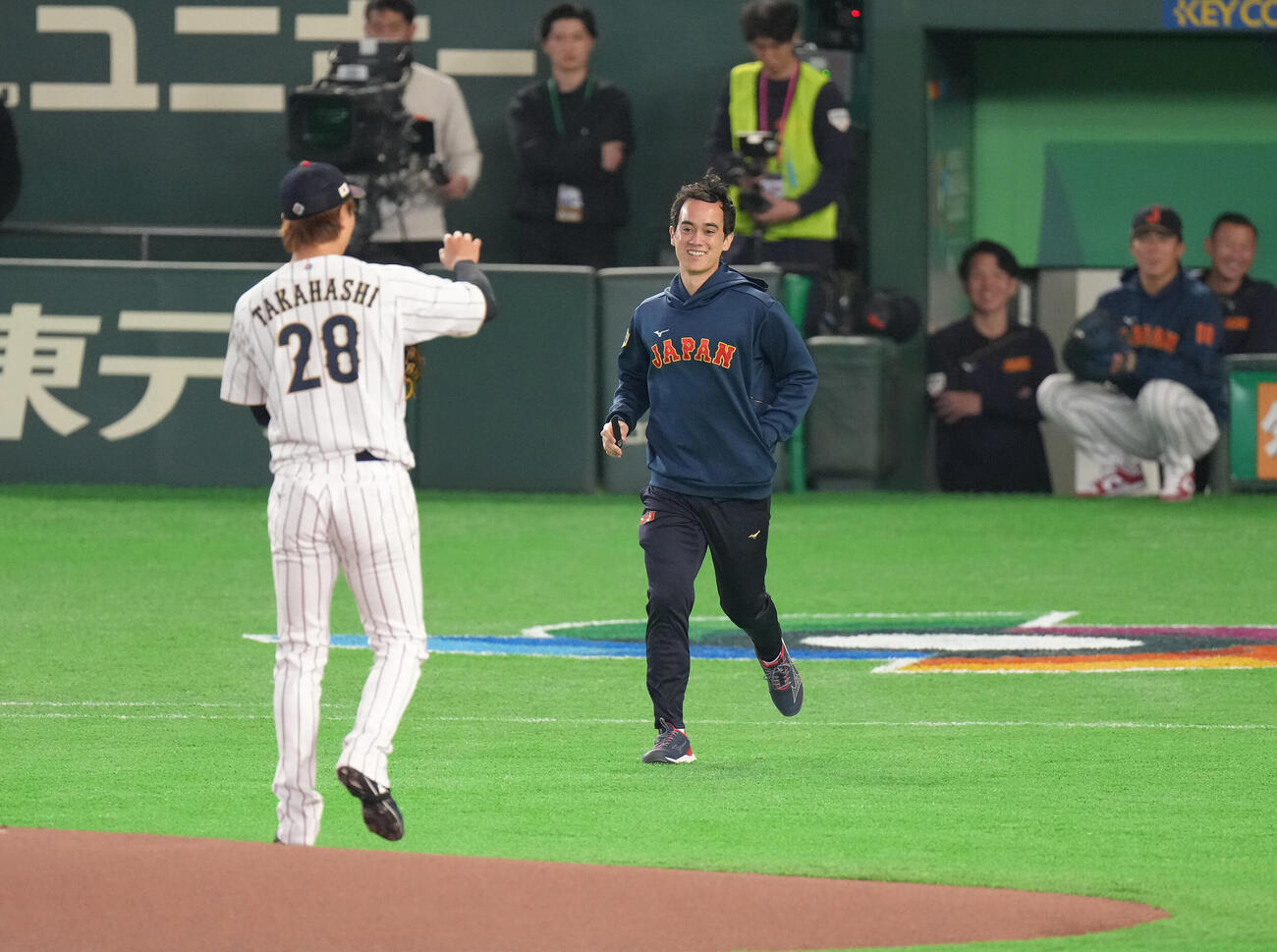 日本対チェコ　試合前、マウンドの高橋宏に通信機器を届けるアイアトン氏（撮影・足立雅史）