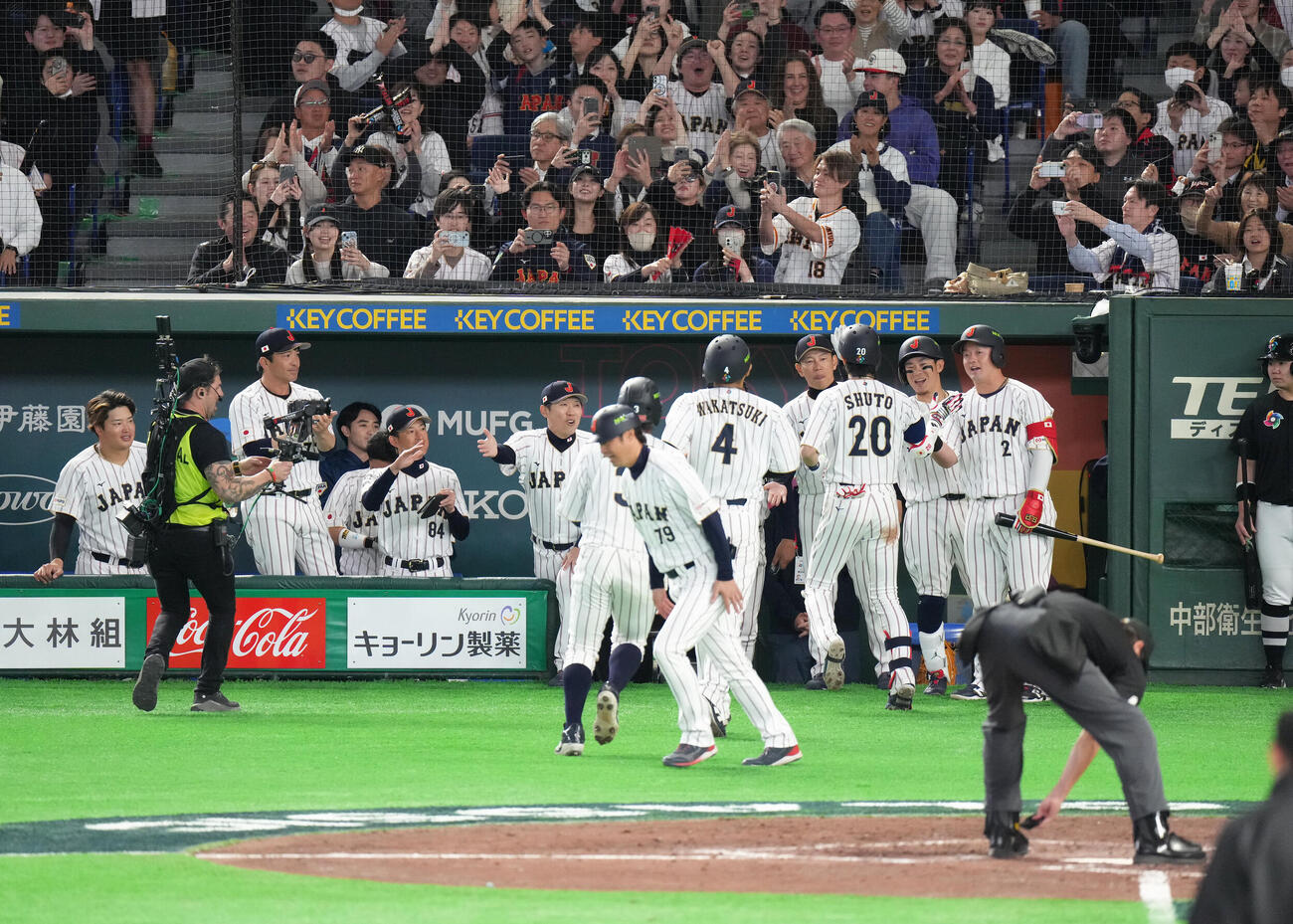 日本対チェコ　8回裏日本2死一、二塁、3点本塁打を放った周東（右から3人目）を迎える井端監督（同4人目）（撮影・足立雅史）