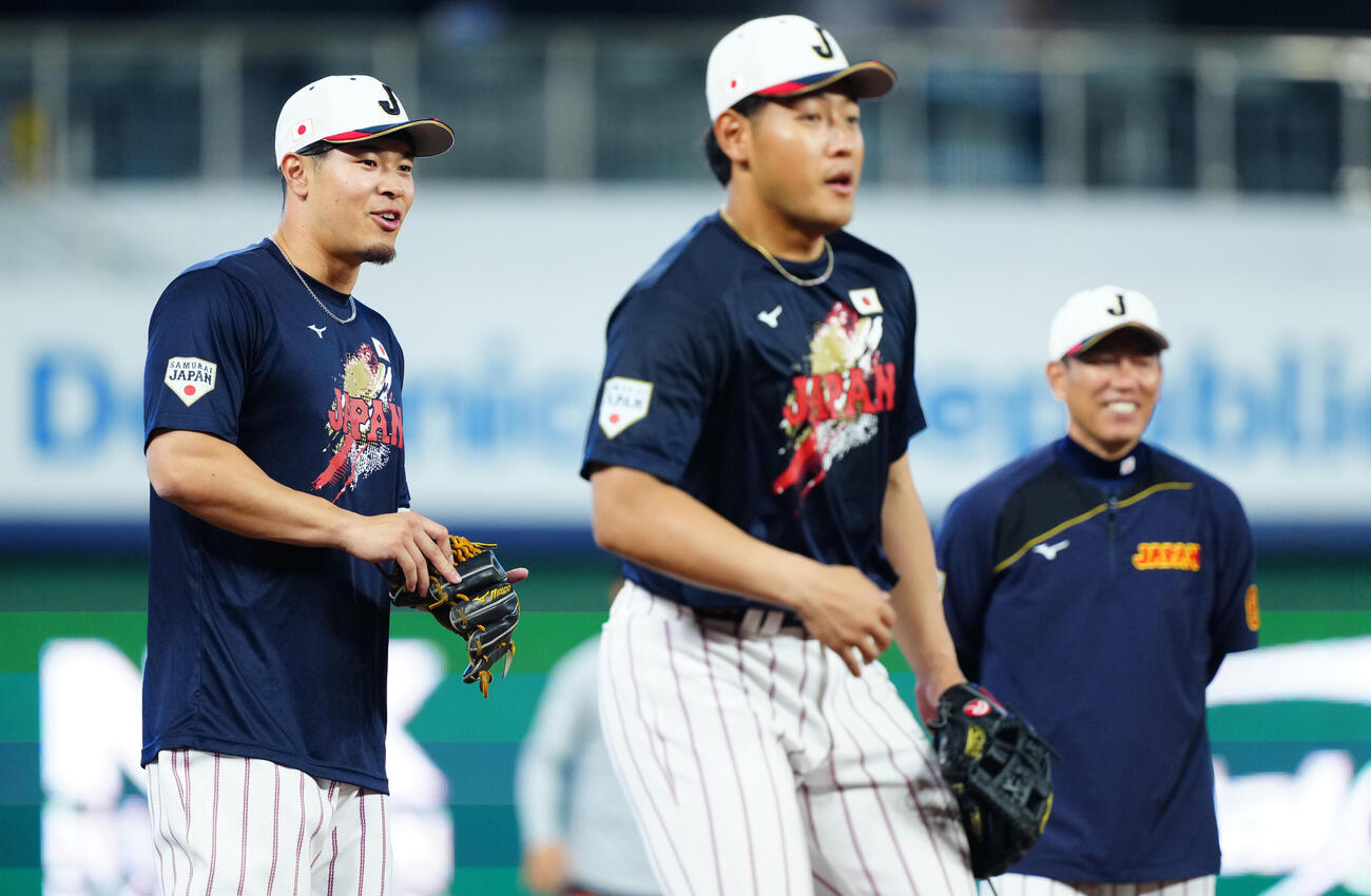 三塁でノックを受ける佐藤輝（左）と岡本（撮影・垰建太）