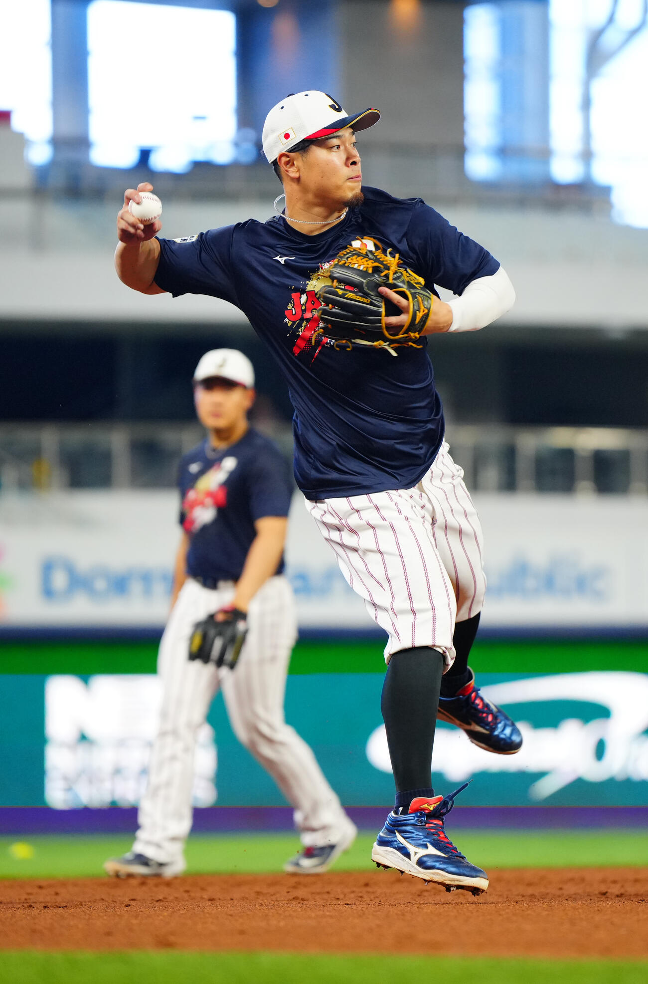 三塁でノックを受ける佐藤輝（手前）と岡本（撮影・垰建太）