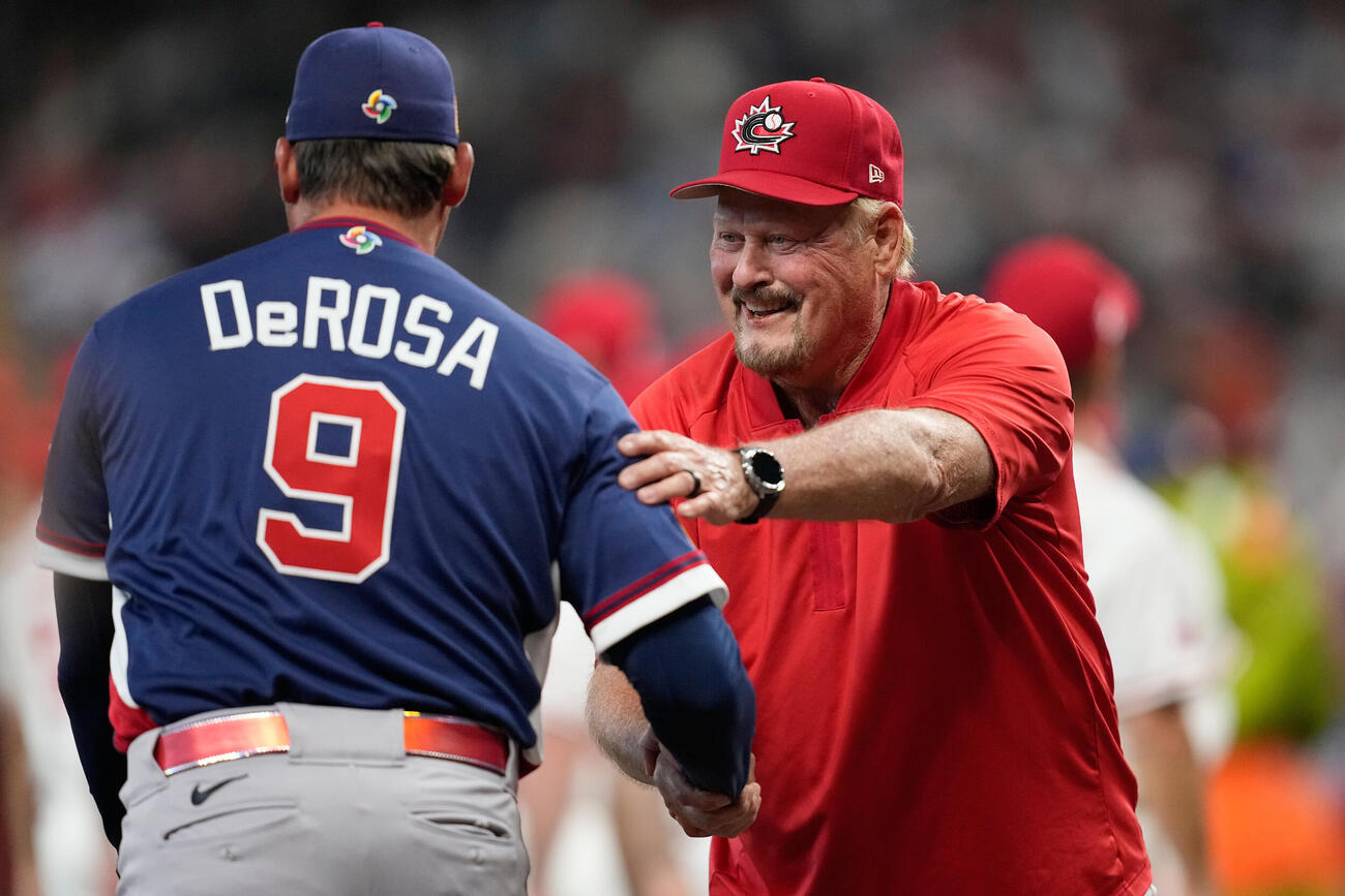 試合前にあいさつを交わす米国のデローサ監督（左）とカナダのウィット監督（AP）