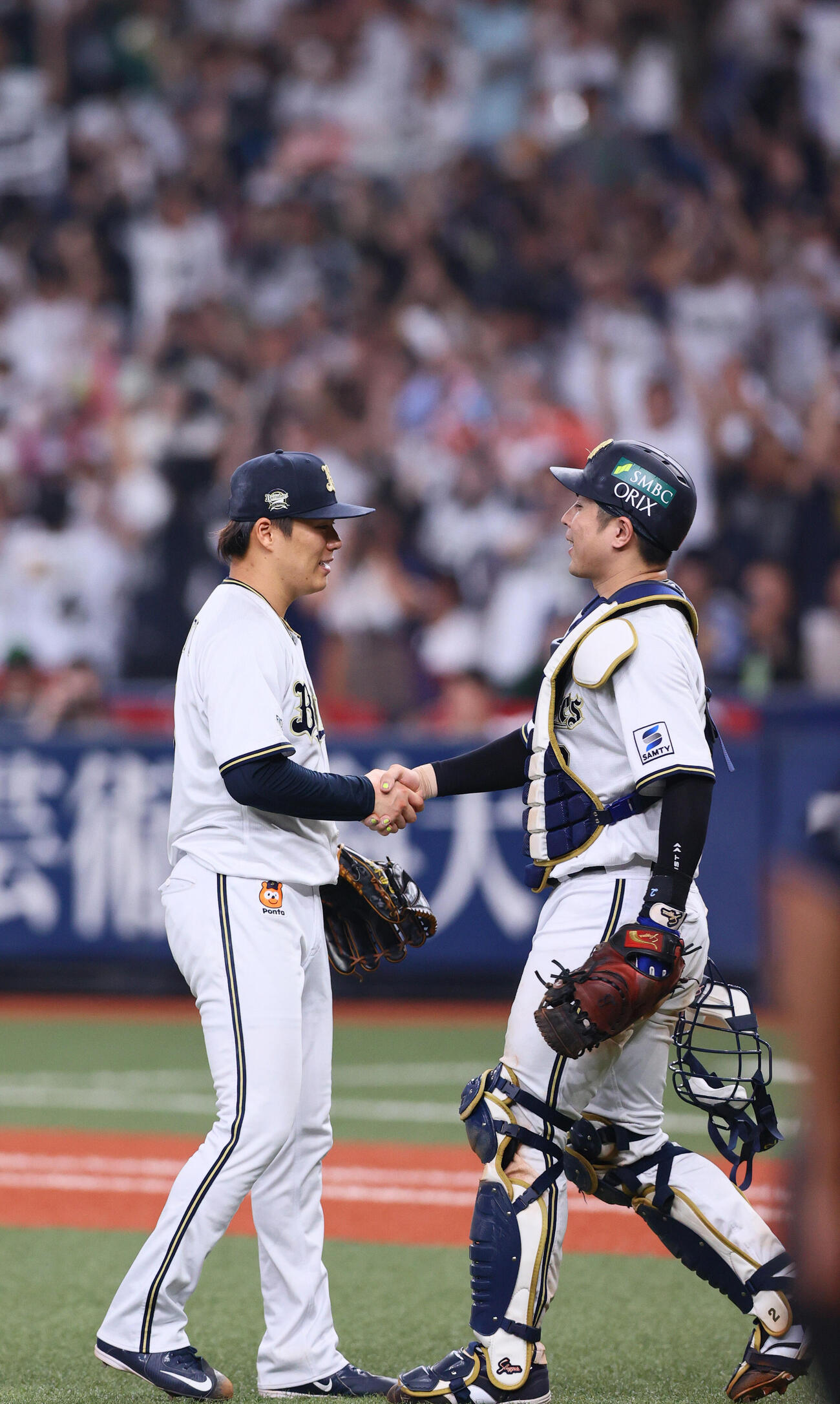 2023年11月、日本シリーズオで阪神に勝利したオリックス山本（左）は捕手若月と笑顔で握手する