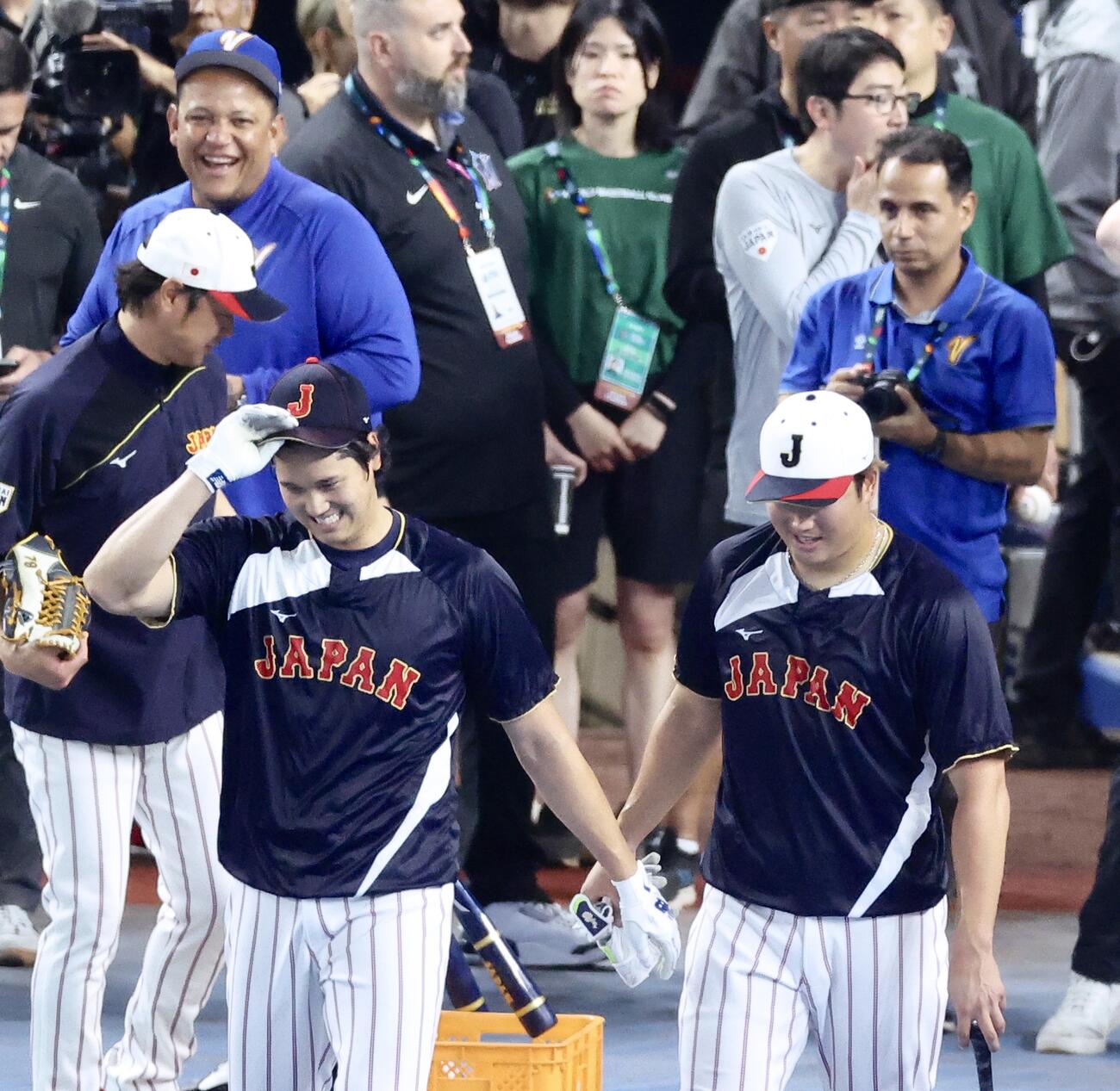 日本対ベネズエラ　試合前、笑顔で球広いに向かう大谷（手前左）と村上。後方左ふベネズエラのミゲル・カブレラ打撃コーチ（撮影・河田真司）