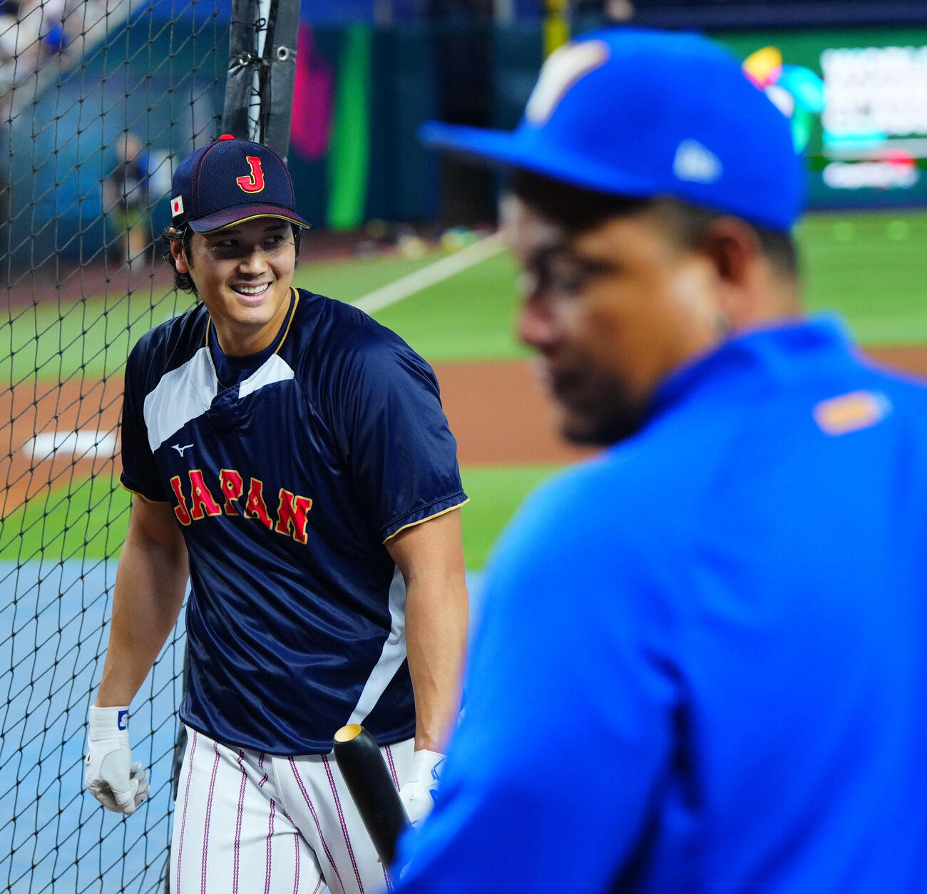 日本対ベネズエラ　試合前、ベネズエラのカブレラ・コーチ（手前）の見つめる前でフリー打撃を行い笑顔を見せる大谷（撮影・垰建太）