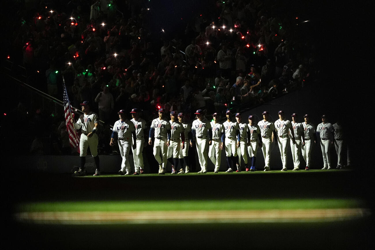 暗転する決勝のグラウンドに入場した米国チーム（AP）