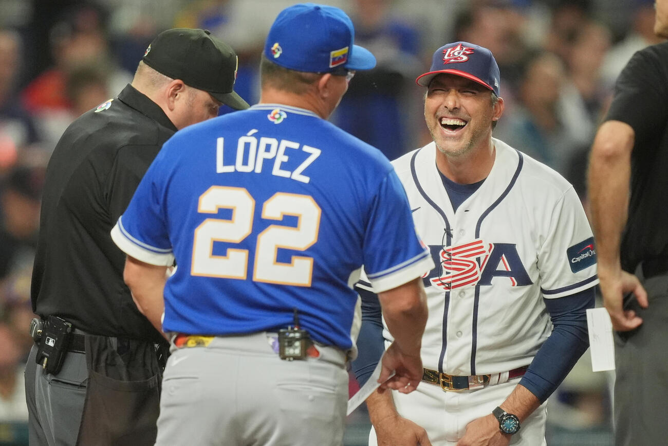 決勝のプレーボール直前、会話を交わすベネズエラのロペス監督と米国のデローサ監督（右、AP）