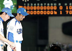 苦笑いを浮かべながらお立ち台から降りる西口文也（右）。左はサヨナラ打の石井義人