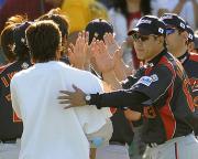 カブスを破り練習試合で連勝し、ナインを迎える原監督(右)(共同)