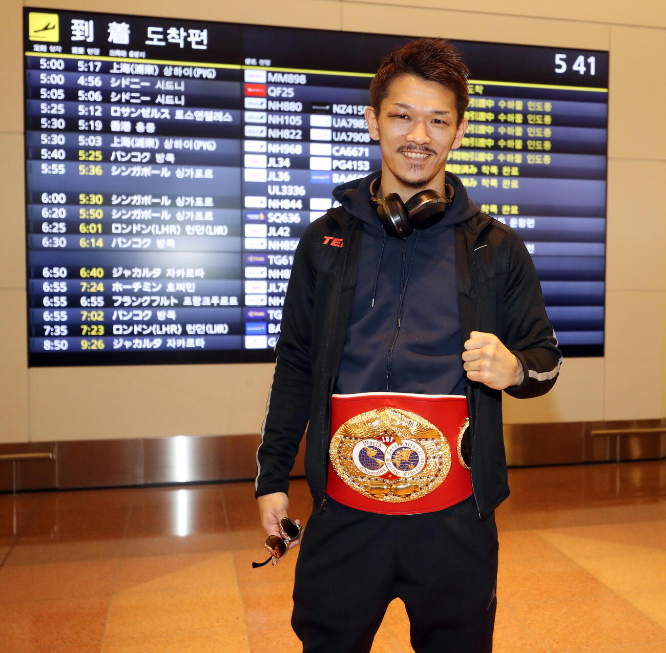 2017年12月、IBF世界スーパーフェザー級王者となった尾川堅一は、帰国した羽田空港でベルトを巻きポーズ