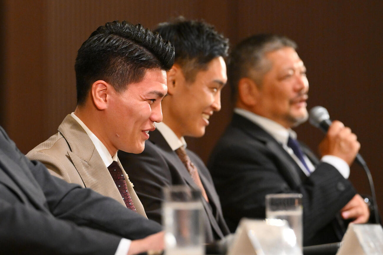 会見で坪井智也（手前）は六島ボクシングジム枝川孝会長（後方）から西田凌佑のスパーリングパートーナー捜しをお願いされ笑顔を見せる（撮影・滝沢徹郎）