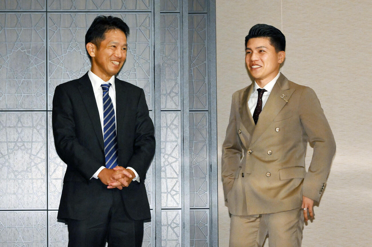 WBC世界スーパーフライ級王座決定戦が決まった坪井智也（右）は田中繊大トレーナーと談笑する（撮影・滝沢徹郎）