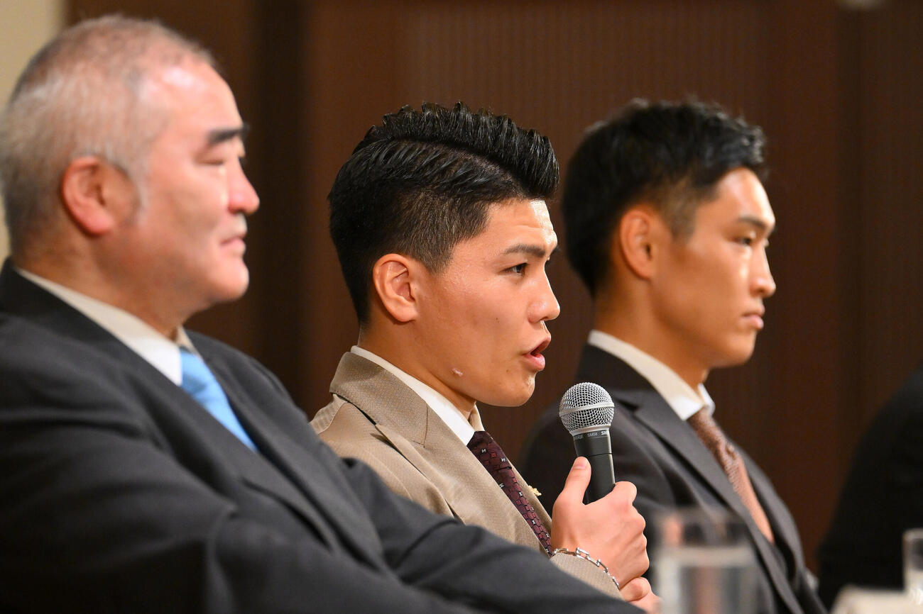 WBC世界スーパーフライ級王座決定戦が決まり会見する坪井智也。手前は帝拳ジム浜田剛史代表、後方は西田凌佑（撮影・滝沢徹郎）