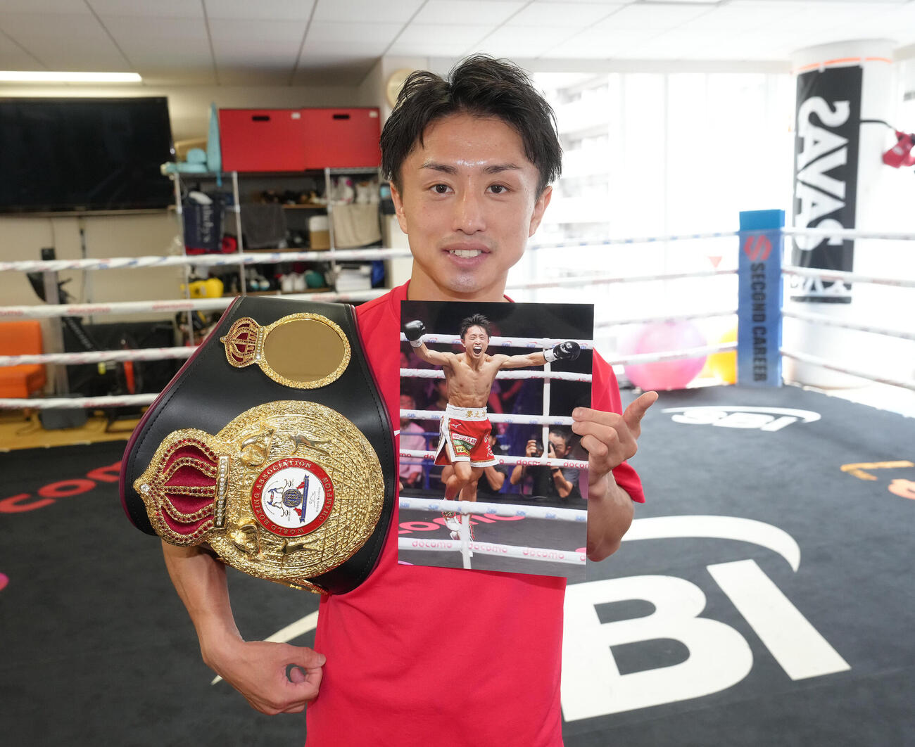 試合から一夜明け、ベルトを手に笑顔を見せるWBA世界ミニマム級王者石井武志（撮影・足立雅史）