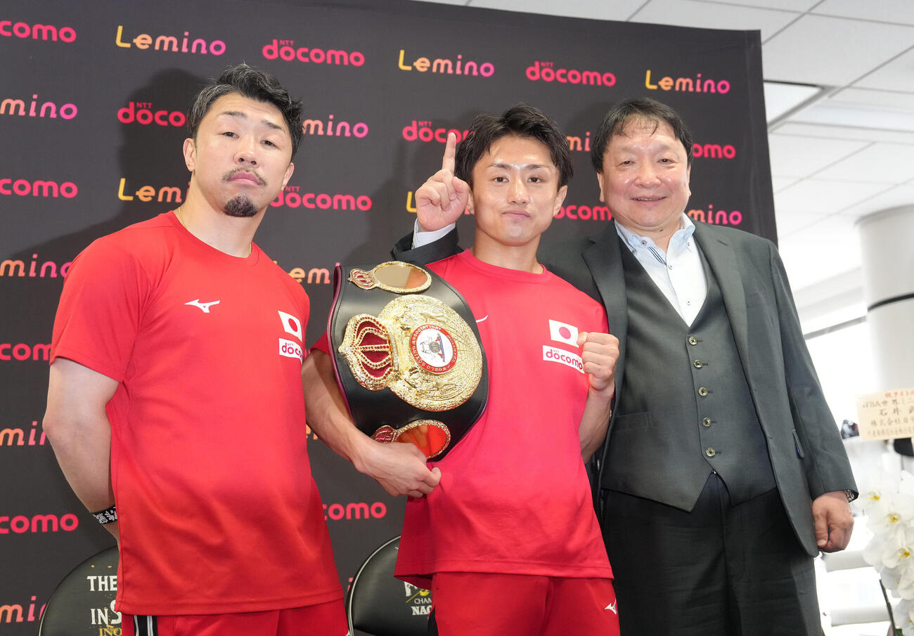 試合から一夜明け、ポーズを決めるWBA世界ミニマム級王者石井武志（中央）。左は八重樫東トレーナー、右は大橋秀行会長（撮影・足立雅史）