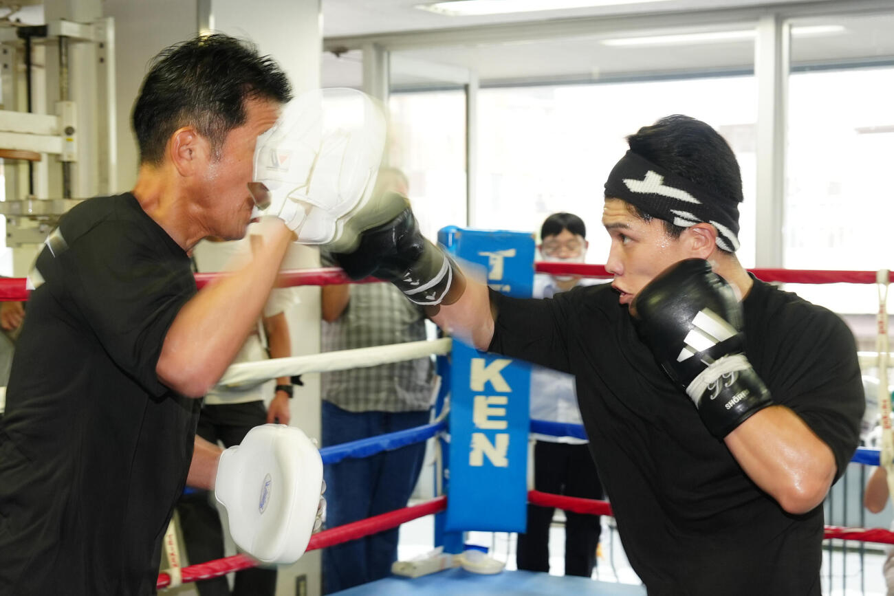 練習を公開し、ミット打ちを行う坪井智也（右）。左は田中繊大トレーナー（撮影・江口和貴）
