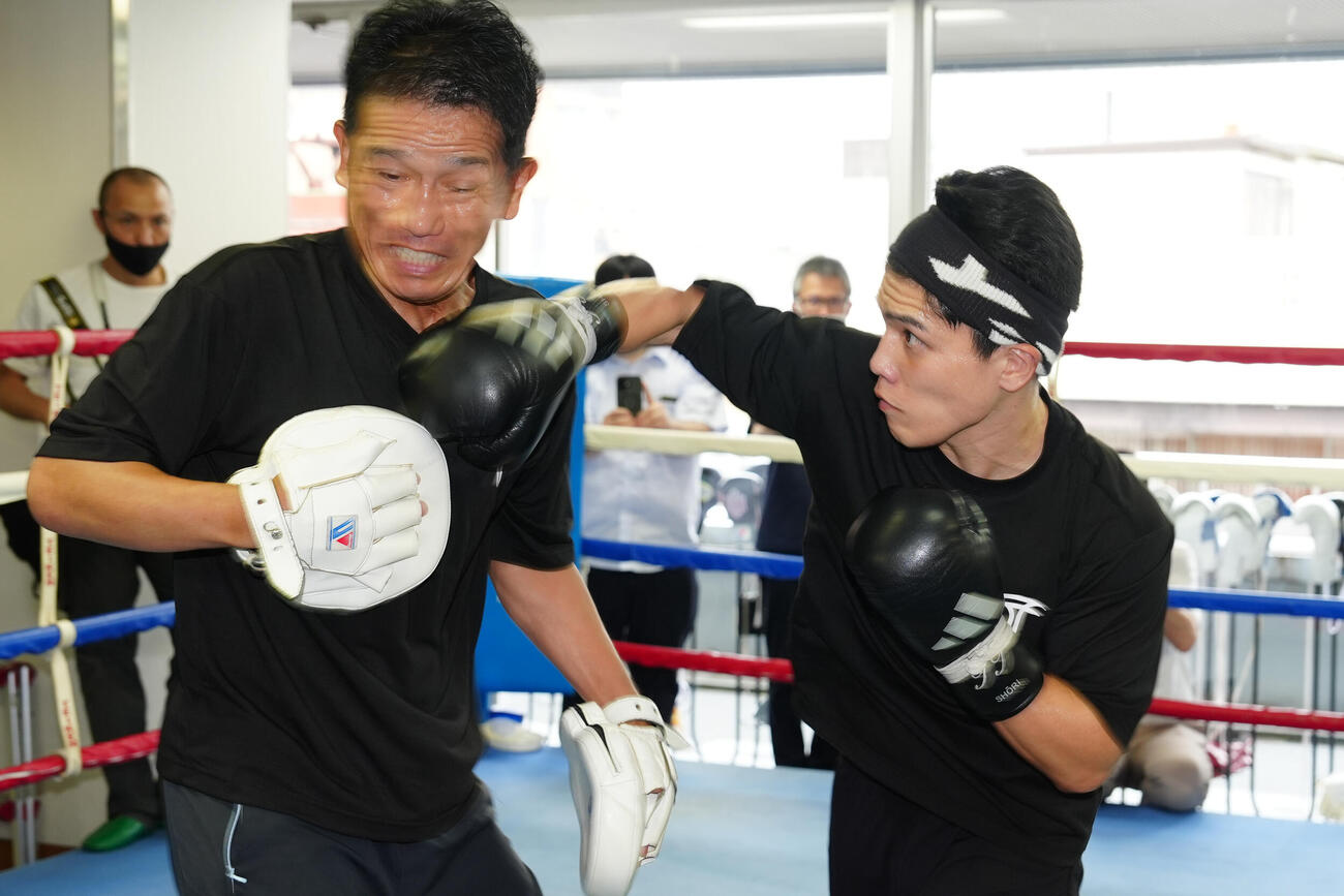 練習を公開し、ミット打ちを行う坪井智也（右）。左は田中繊大トレーナー（撮影・江口和貴）