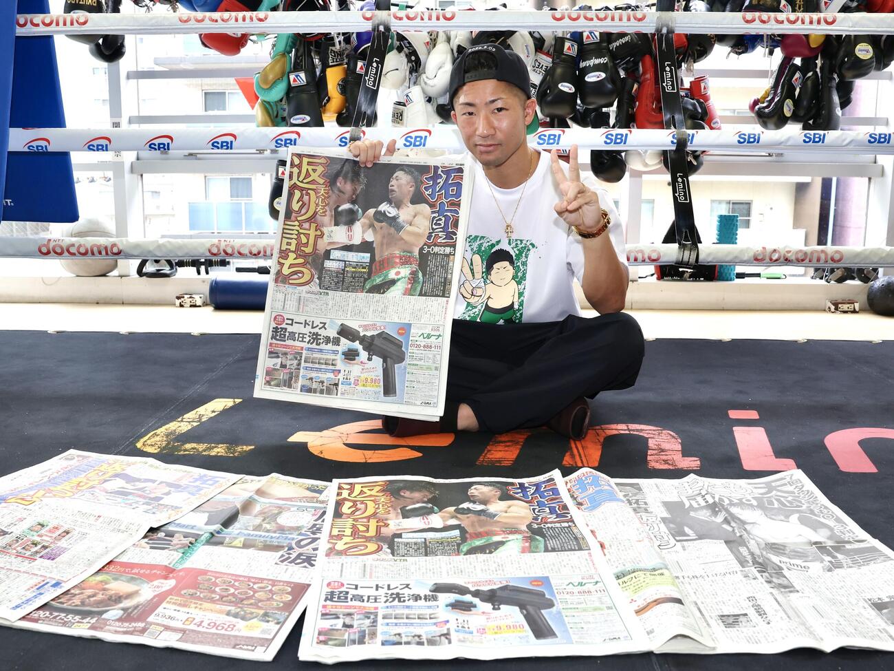 那須川天心戦から一夜明け、本紙を手に笑顔を見せる井上拓真（撮影・宮地輝）