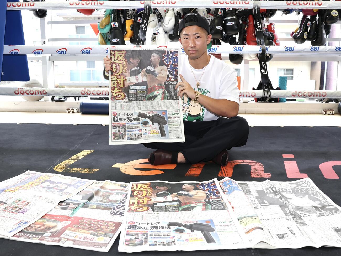 那須川天心戦から一夜明け、本紙を手に笑顔を見せる井上拓真（撮影・宮地輝）