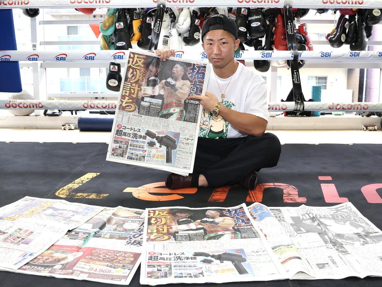那須川天心戦から一夜明け、本紙を手に笑顔を見せる井上拓真（撮影・宮地輝）