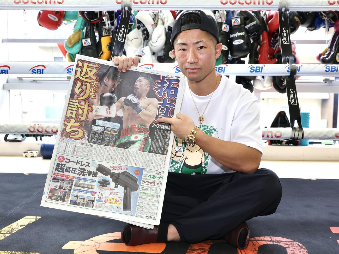 那須川天心戦から一夜明け、本紙を手に笑顔を見せる井上拓真（撮影・宮地輝）