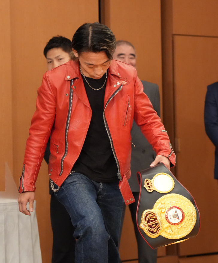 フォトセッションの途中で降壇し自らのベルトを持ち込む挑戦者の堤聖也（撮影・小沢裕）