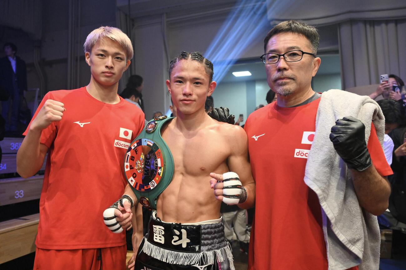 試合後、東洋太平洋ライトフライ級王座になった片岡雷斗（中央）は弟の叶夢（左）、父の圭トレーナーと写真に納まる（撮影・滝沢徹郎）