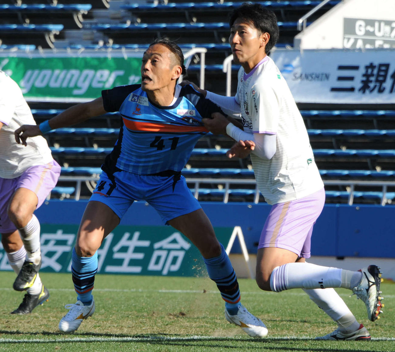 20年12月のサッカー選手の現役最終戦でプレーする安彦考真（左）