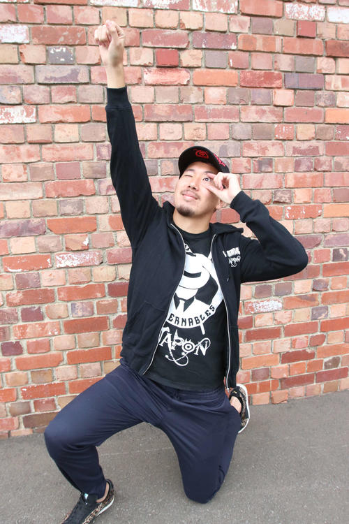 帽子＆パーカ＆Tシャツのグッズを着て内藤のポーズを決める福森（撮影・西塚祐司）