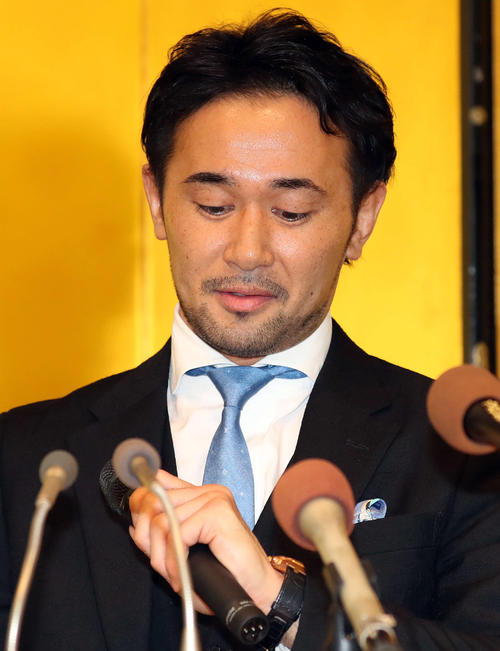 引退会見を行った山中慎介さんは神の左と呼ばれた手をじっと見つめる（撮影・松本俊）