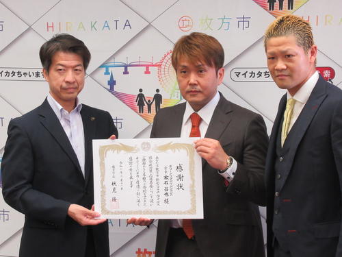 枚方市の伏見市長（左）から感謝状を贈られるグリーンツダジムの本石会長（中央）と矢田（2020年6月11日撮影）