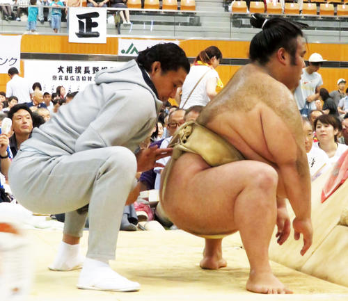 巡業の朝稽古中に、弟子の貴景勝（右）の背後について四股の踏み方を熱心に指導する貴乃花親方（2018年8月5日撮影）