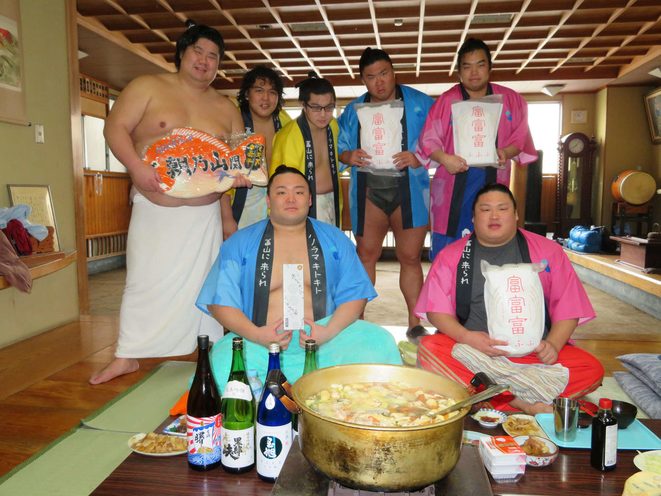 富山の食材を手に笑顔を見せる朝乃山（前列左）ら高砂部屋の力士（2020年2月7日撮影）