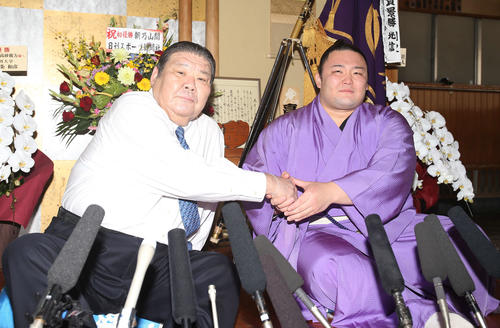 元朝潮の錦島親方（左）と握手を交わす朝乃山（2019年5月27日撮影）