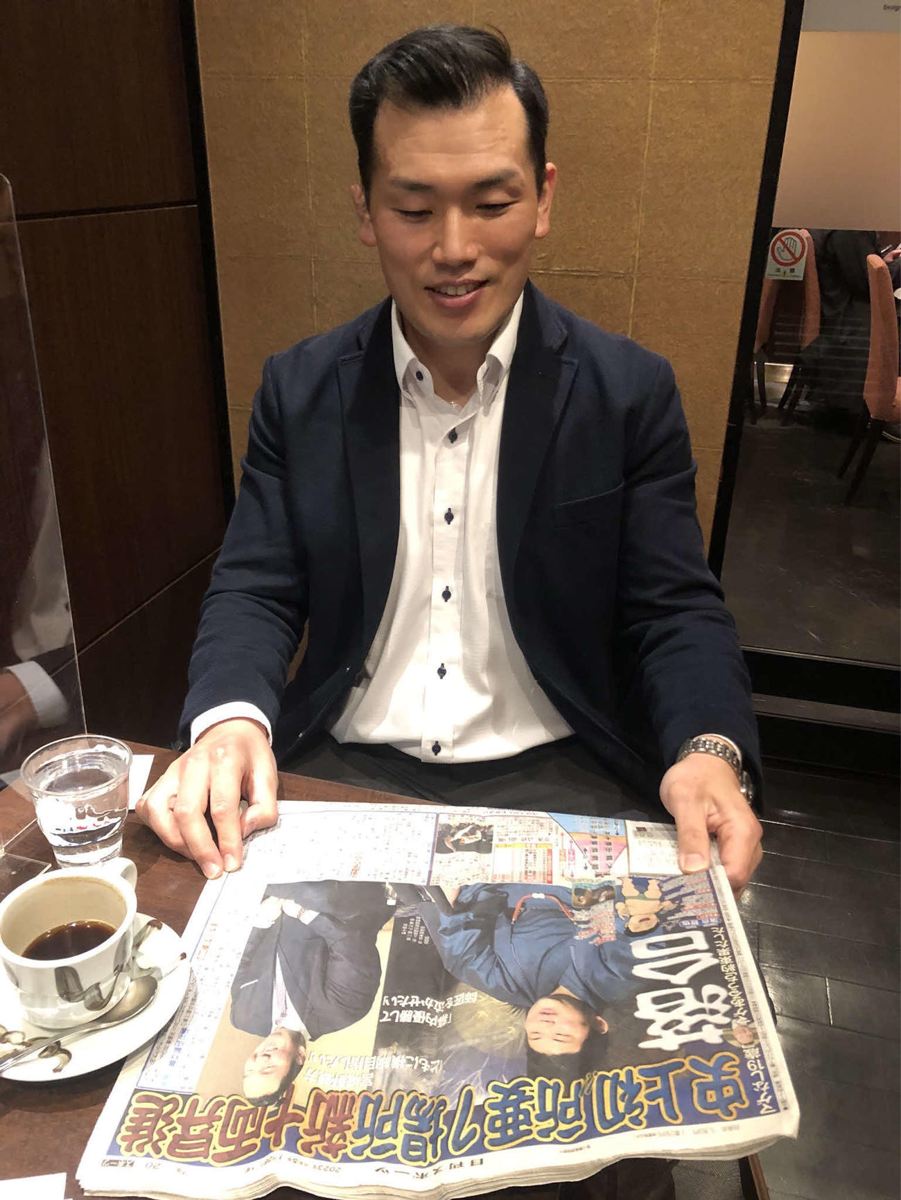 師匠の宮城野親方と新十両会見に臨んだ落合の記事を眺める、元幕下・下田の下田圭将さん（撮影・平山連）
