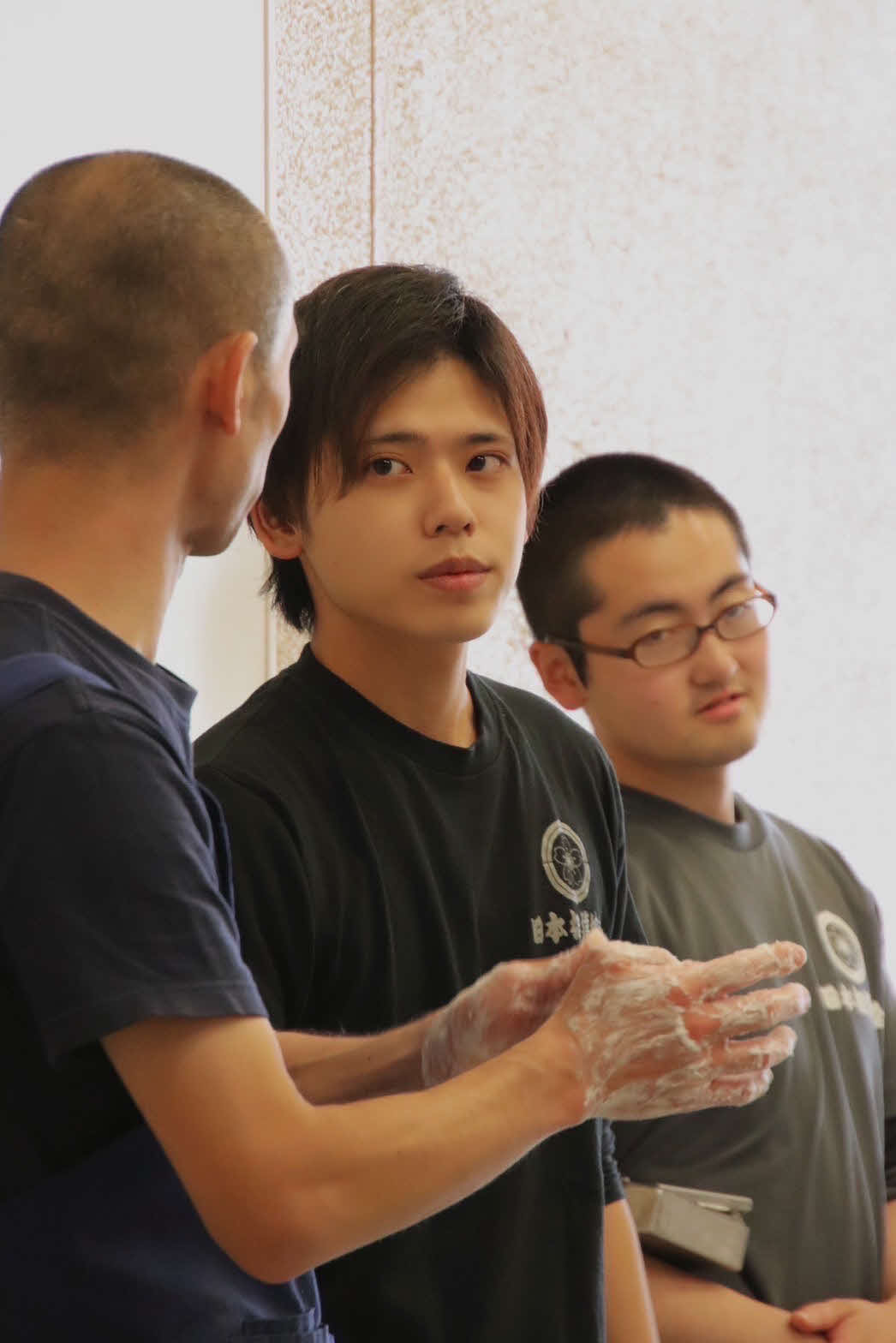2020年9月まで床山の床玉として日本相撲協会に所属した志賀龍さん（中央）。現在は美容師を目指している（志賀さん提供）