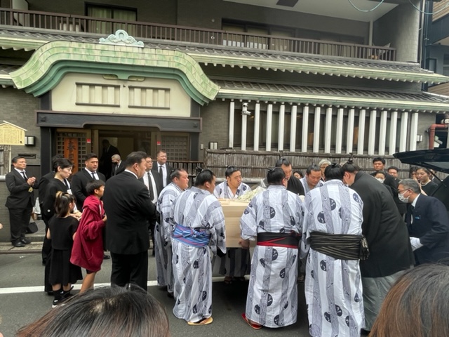 故岩友親方の棺を運び出す若い衆と、それを見守る師匠の春日野親方（背中）