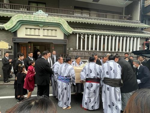 故岩友親方の棺を運び出す若い衆と、それを見守る師匠の春日野親方（背中）