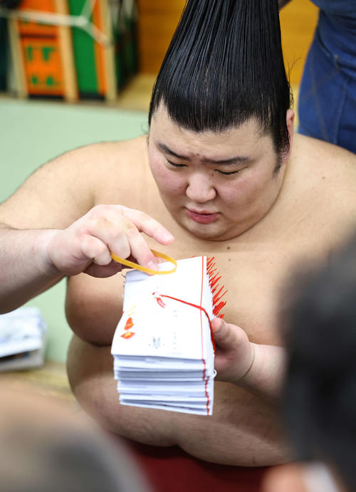 1月17日、懸賞金の束を見つめる熱海富士
