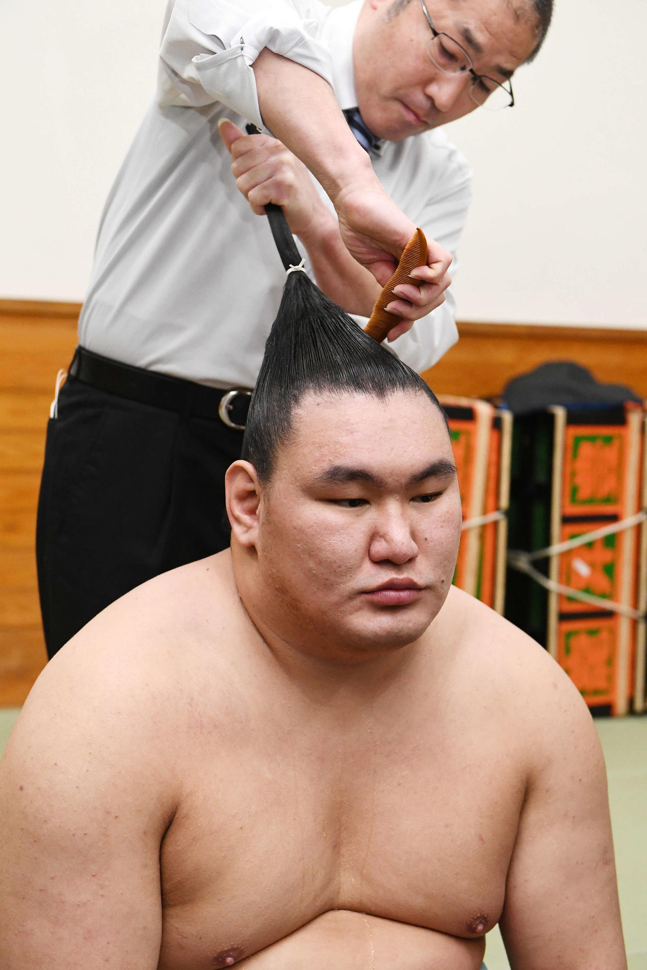 15日、支度部屋で豊昇龍の髪を整える床秀
