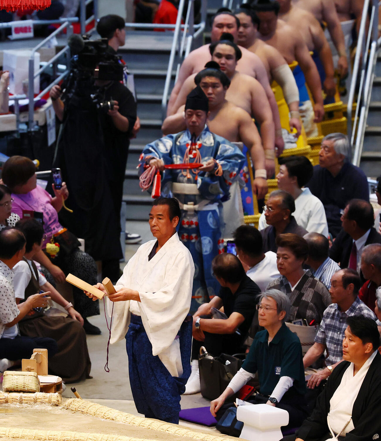 幕の内土俵入りで拍子木を打ち鳴らす呼び出しの幸吉（撮影・加藤哉）